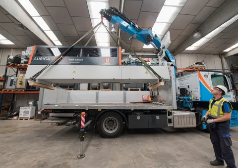 Servicio de transporte logístico. Camión pluma cargando un cnc